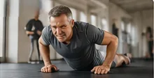 Adult doing push-ups in a gym.